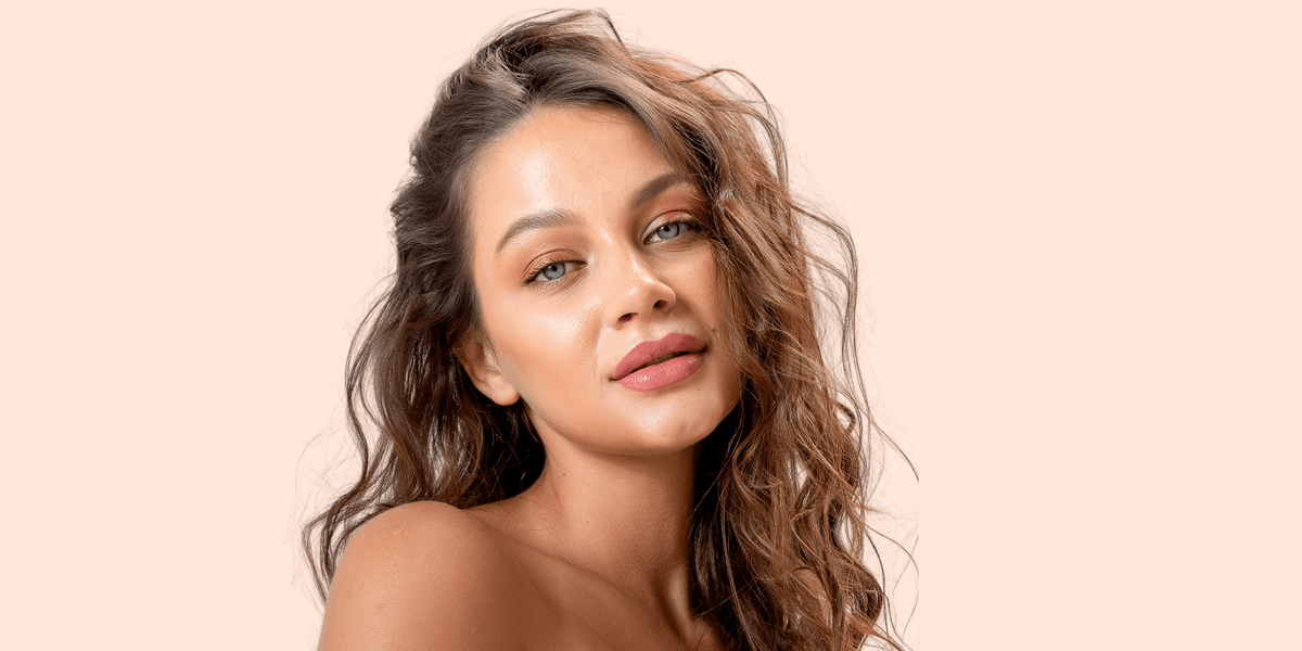 Woman with wavy hair against a beige background